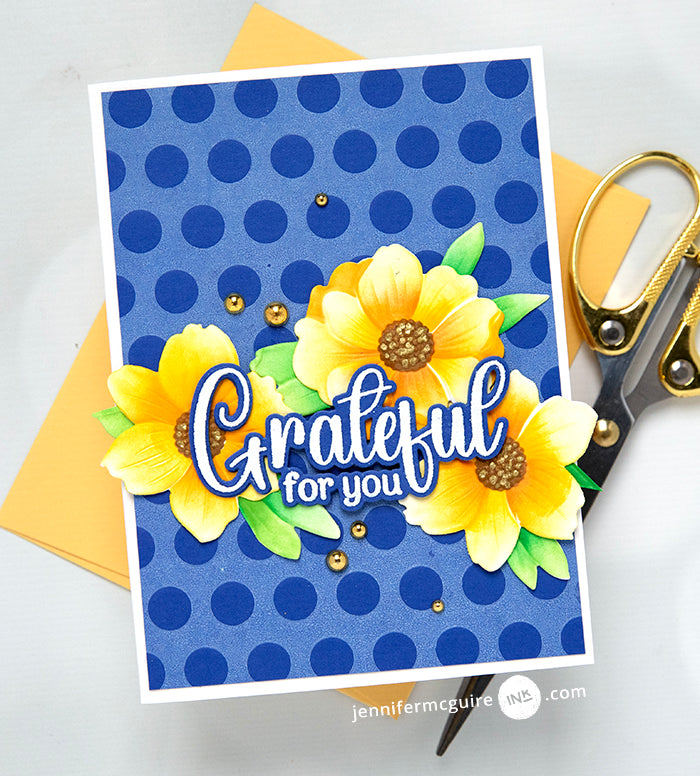 Gina K Designs Dancing Leaves Stamps and Dies blue card with dark blue polka dots as background. yellow flowers with green leaves and the sentiment grateful for you | color-code:alt2