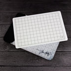 Tim Holtz Tonic Travel Glass Studio Mat 2634e Mat On Zipper Bag on Woodgrain Background