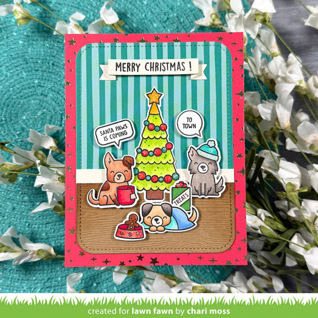 A handmade Christmas greeting card featuring cartoon dogs by a decorated tree, with the text 'MERRY CHRISTMAS!' at the top, styled on a teal textured background with white flowers.