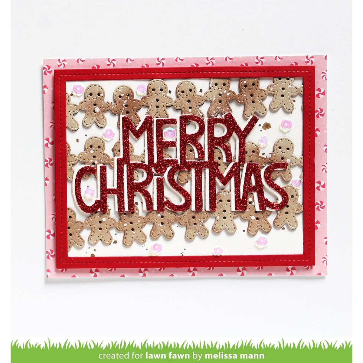A handmade Christmas greeting card featuring the words 'MERRY CHRISTMAS' in glittery red letters, surrounded by small gingerbread men cutouts. The card has layered red borders and a pink patterned outer border, shown against a plain white background.