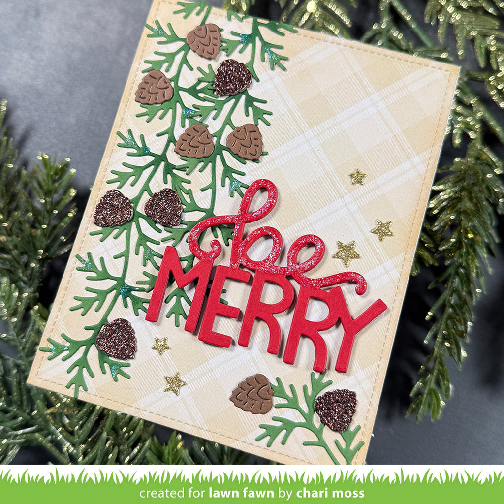 A handmade Christmas greeting card with a beige plaid background, green pine branches, brown pinecones, and glittery red 'Merry' lettering, styled with green pine branches.