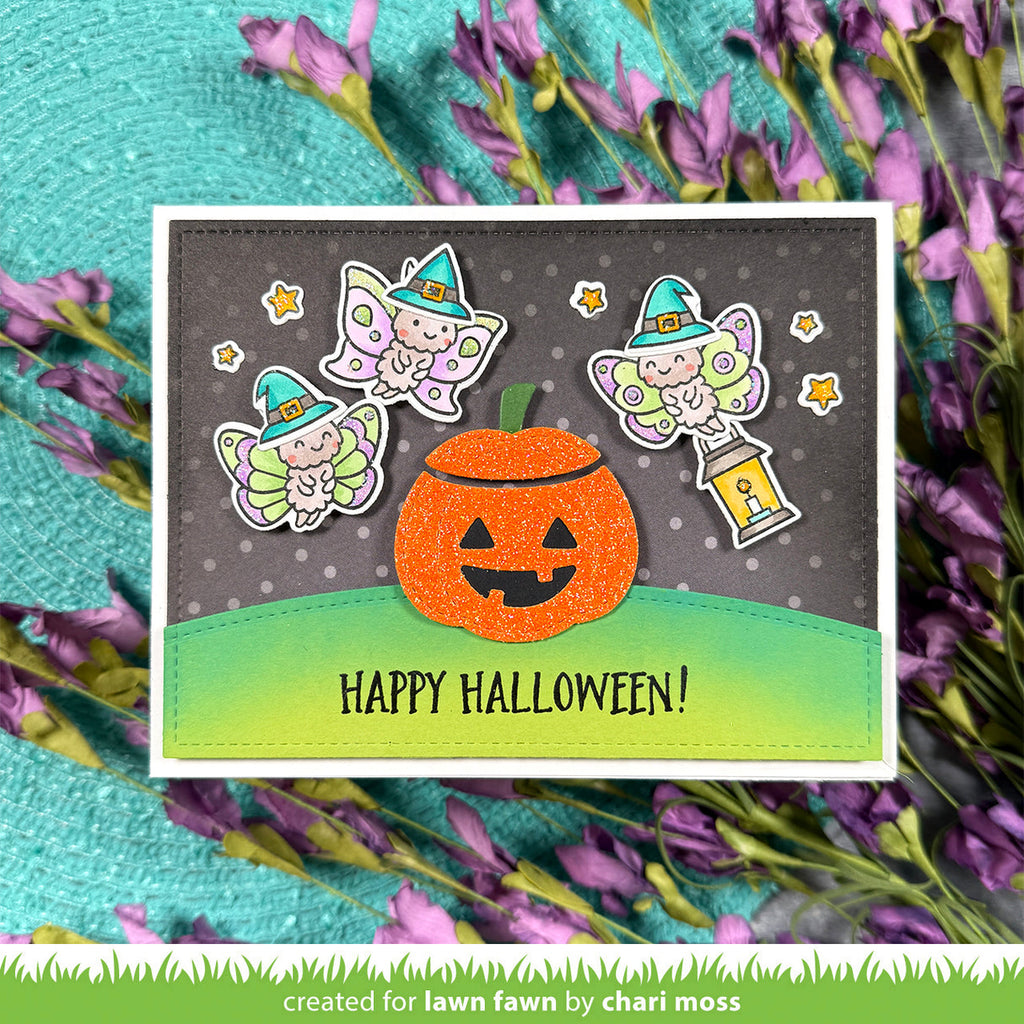 A handmade Halloween greeting card featuring a glittery orange jack-o'-lantern, two cute fairy stickers, and a green gradient grass base with the text 'HAPPY HALLOWEEN!'. | color-code:alt1