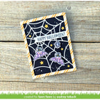 A handmade Halloween greeting card featuring cute purple bats, a spider, and stars on a black background with a spiderweb pattern and orange-and-white striped border.