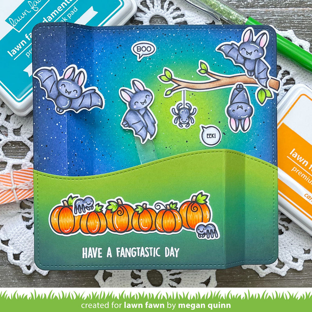 A handmade dimensional card featuring a Halloween-themed design with cute bat stickers, orange pumpkins, and the text 'HAVE A FANTASTIC DAY'.
