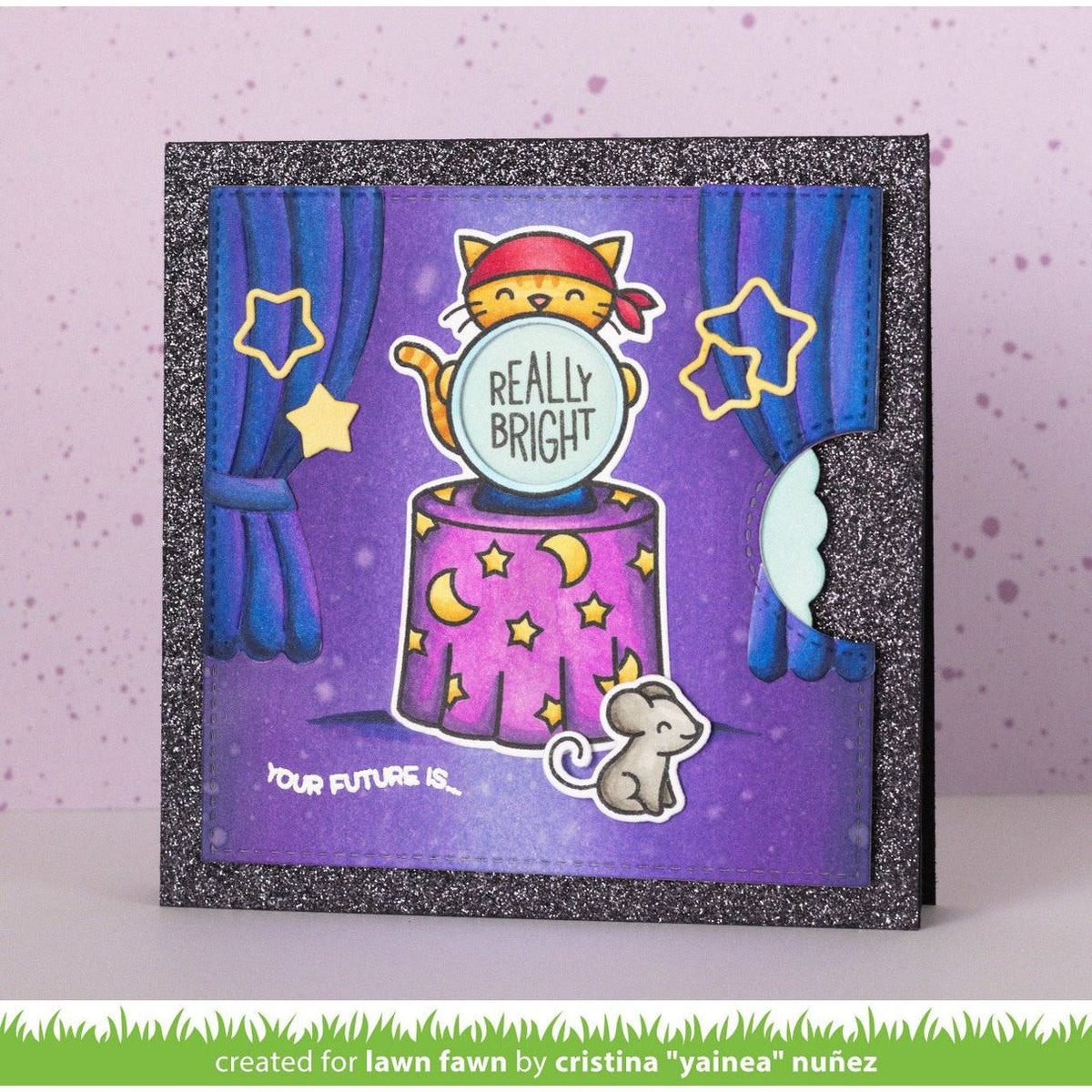 A handmade glittery greeting card featuring a whimsical illustration of a yellow cat in a red bandana behind a purple crystal ball that reads 'REALLY BRIGHT'. The card has a purple background with blue curtains, yellow stars and moons, and a small gray mouse.