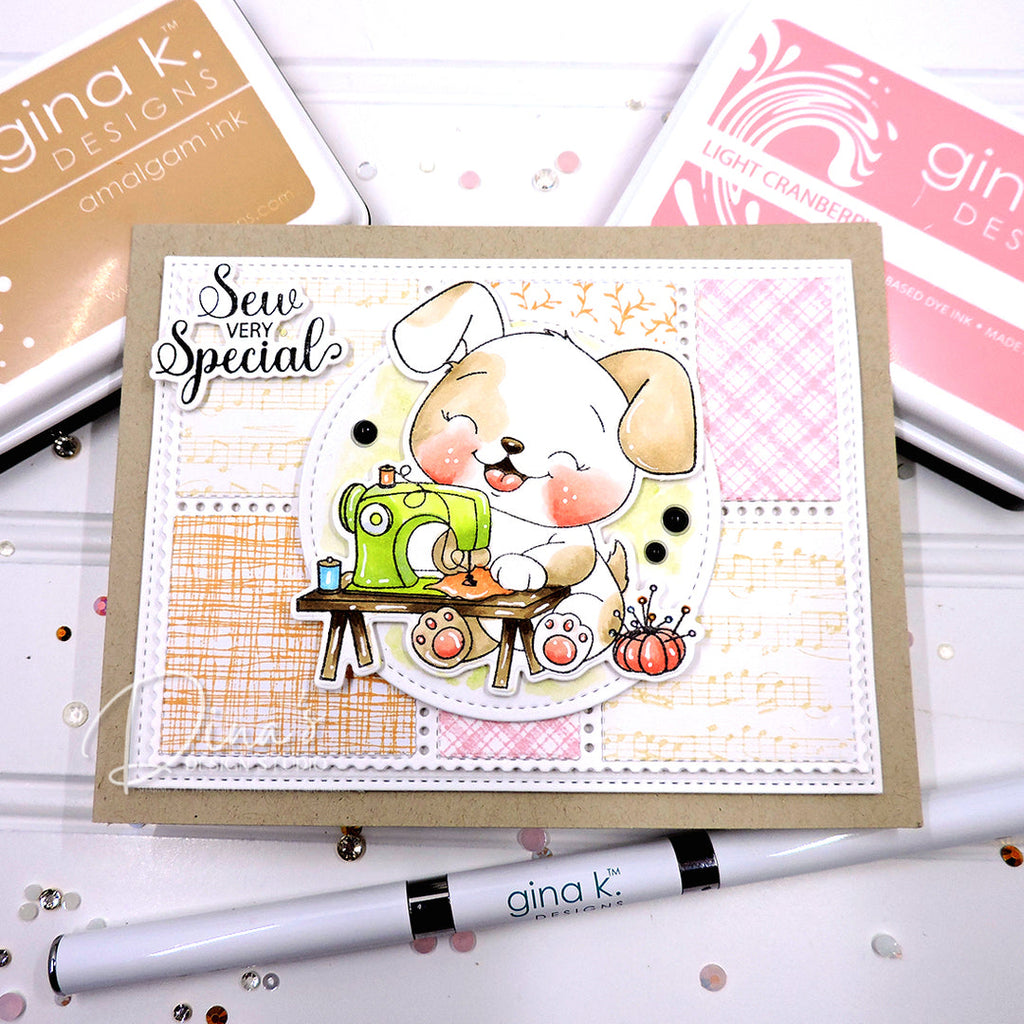 A handmade greeting card featuring a cute puppy sewing with a green sewing machine, styled on a kraft card base with layered white and pink patterned paper. The card is surrounded by Gina K.