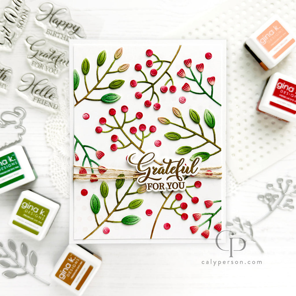 A handmade greeting card featuring green leaves and red berries on a white background, with a central die-cut phrase 'Grateful FOR YOU' and twine detail. 