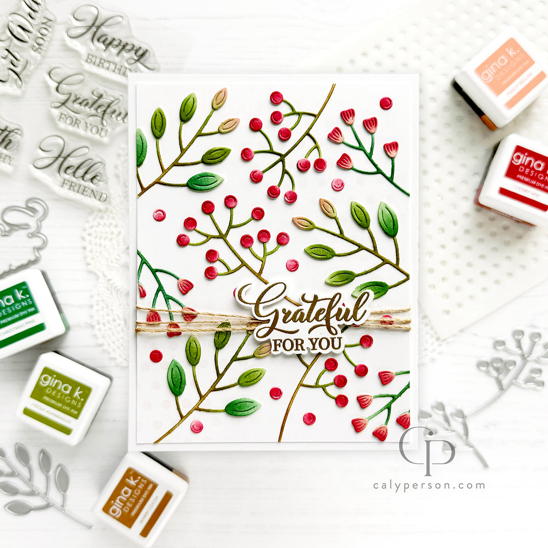 A handmade greeting card featuring green leaves and red berries on a white background, with a central die-cut phrase 'Grateful FOR YOU' and twine detail. 