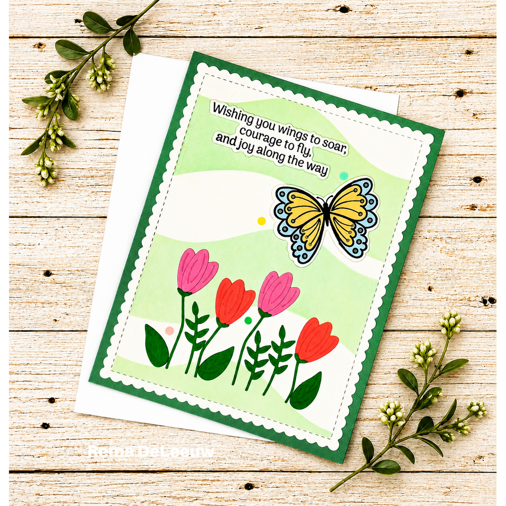 A handmade greeting card with a green border, scalloped white edge, a yellow butterfly, pink and red tulips, and a quote, displayed on a white envelope over a light wood background with green sprigs.