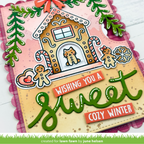 A handmade holiday greeting card featuring a gingerbread house with a cat, candy canes, gingerbread figures, and the text 'Wishing you a Sweet Cozy Winter' in green and orange lettering.