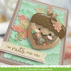 A handmade layered card featuring a cute acorn face with sequins inside, autumn leaves, and a banner that reads 'I'M nuts FOR YOU'.
