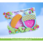 A handmade layered card featuring cute acorns and leaves with pink faces and colorful acorn details, with the text 'HAPPY HALLOWEEN' on a pastel plaid background. A green banner at the bottom reads 'created for lawn fawn by latisha yoast'.
