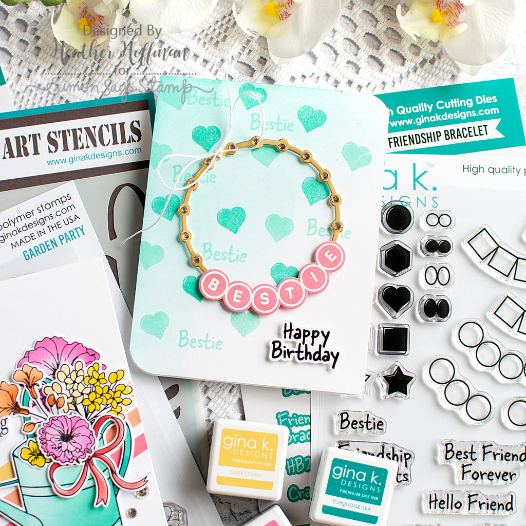 A styled flat-lay of crafting supplies and a handmade friendship bracelet. The central product is a gold-tone circular charm bracelet with pink round beads spelling 'BESTIE' and a black stamped 'Happy Birthday'