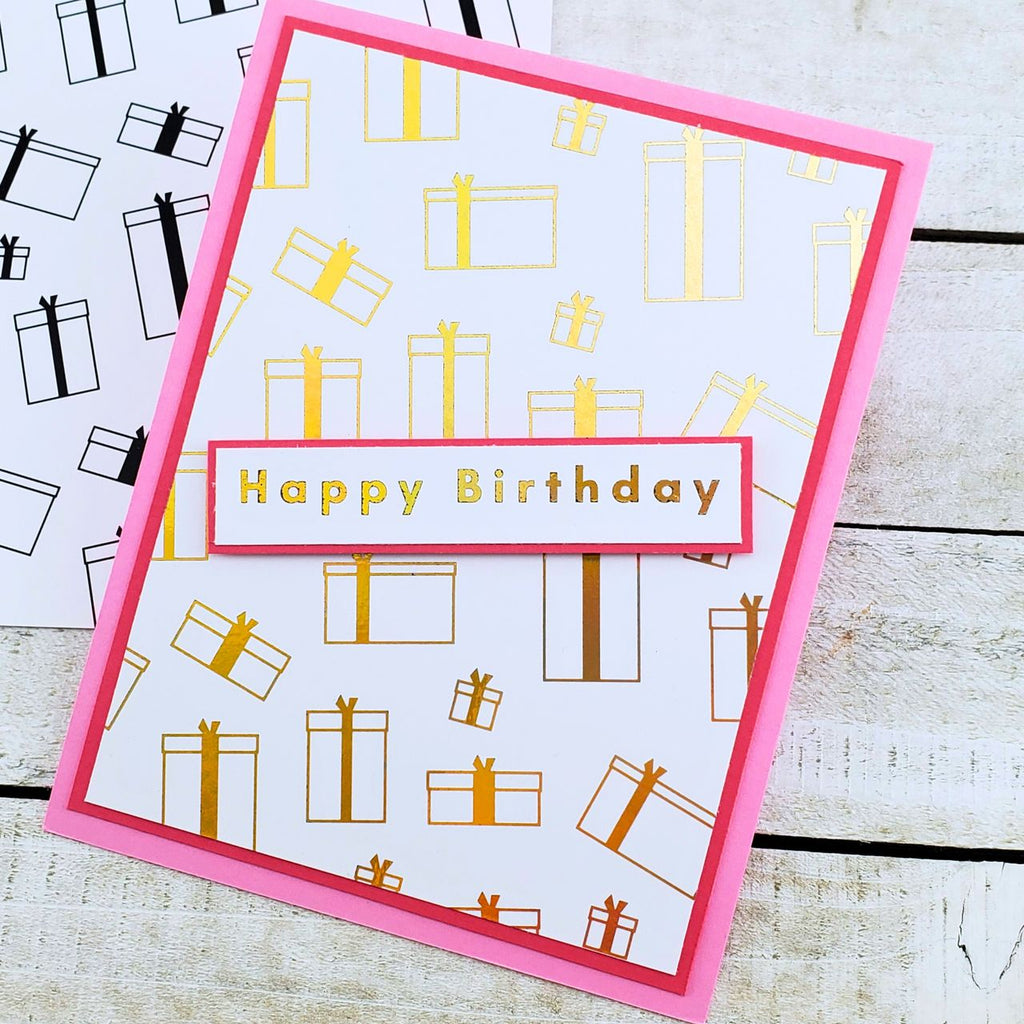 Birthday card with gift box pattern and 'Happy Birthday' text on a wooden surface.