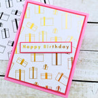 Birthday card with gift box pattern and 'Happy Birthday' text on a wooden surface.