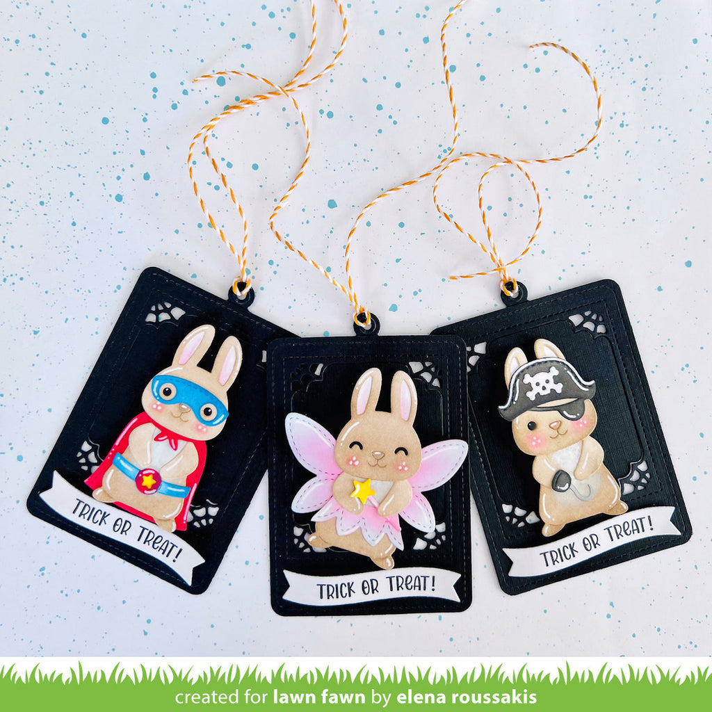 Three Halloween-themed rabbit figurines on black cards with decorative strings against a light blue background.