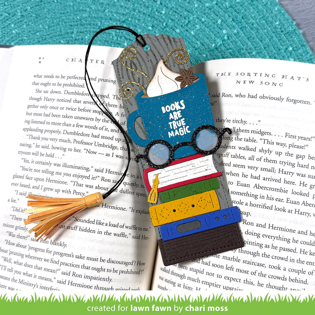 Colorful bookmark with glasses, books, and tassel on an open book | color-code:alt1