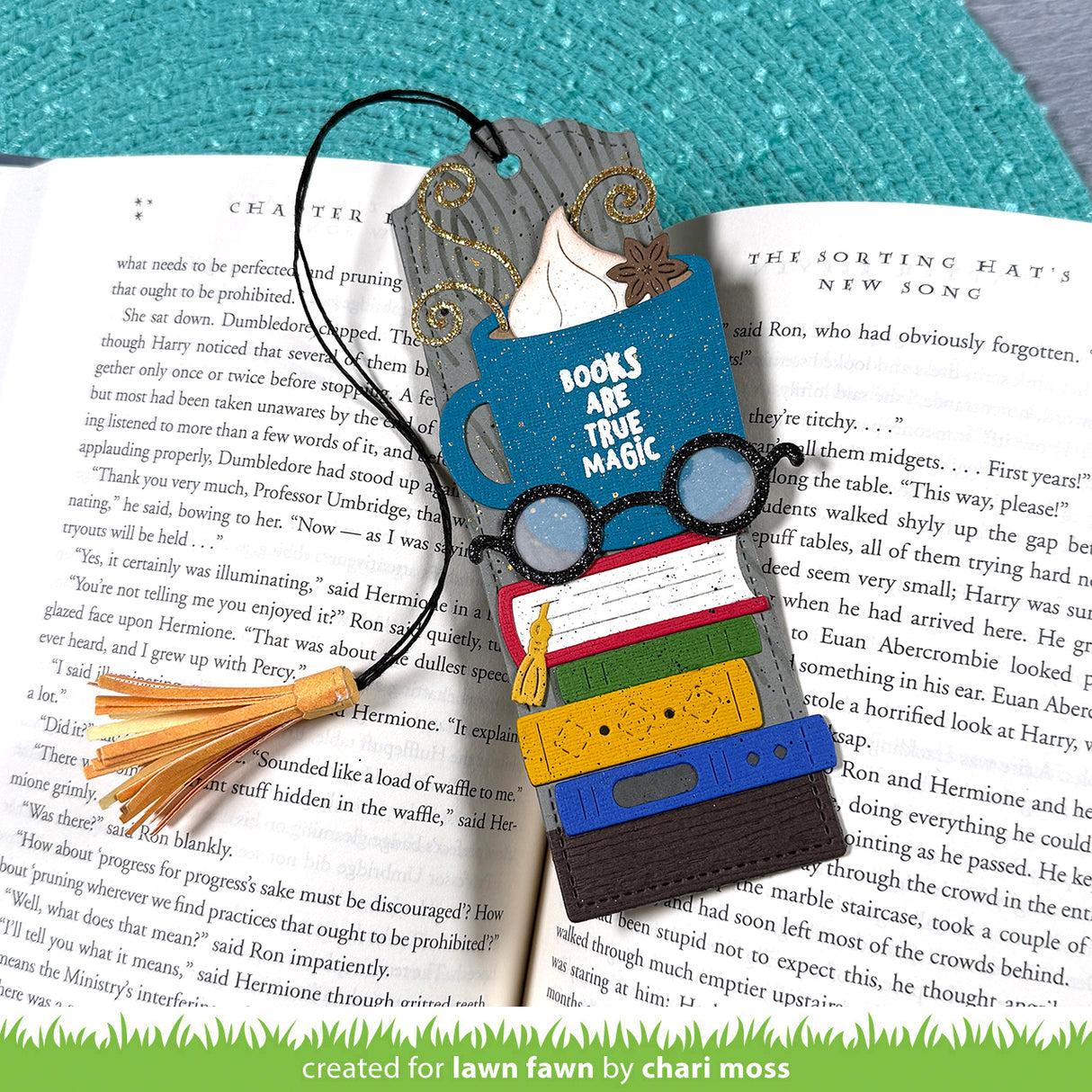Colorful bookmark with glasses, books, and tassel on an open book | color-code:alt1