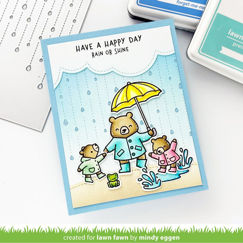 Card with bears in raincoats and an umbrella, text 'Have a happy day rain or shine', on a white background.