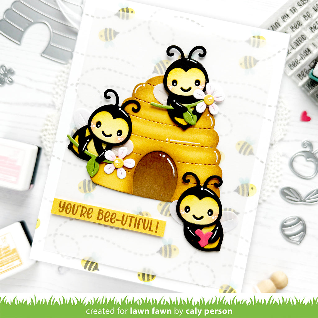 Card with bee-themed design and 'You're Bee-utiful!' text, surrounded by crafting tools.