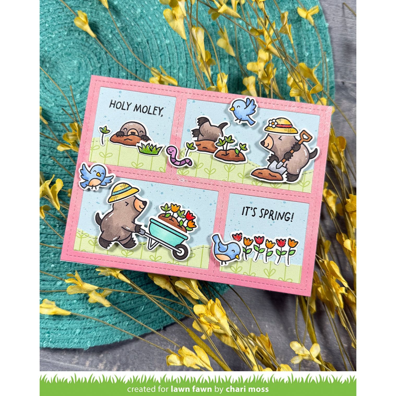 Card with moles and birds and text on a pink border, surrounded by yellow flowers and green leaves.