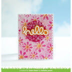 Card with pink floral design and 'hello' text on a blurred outdoor background