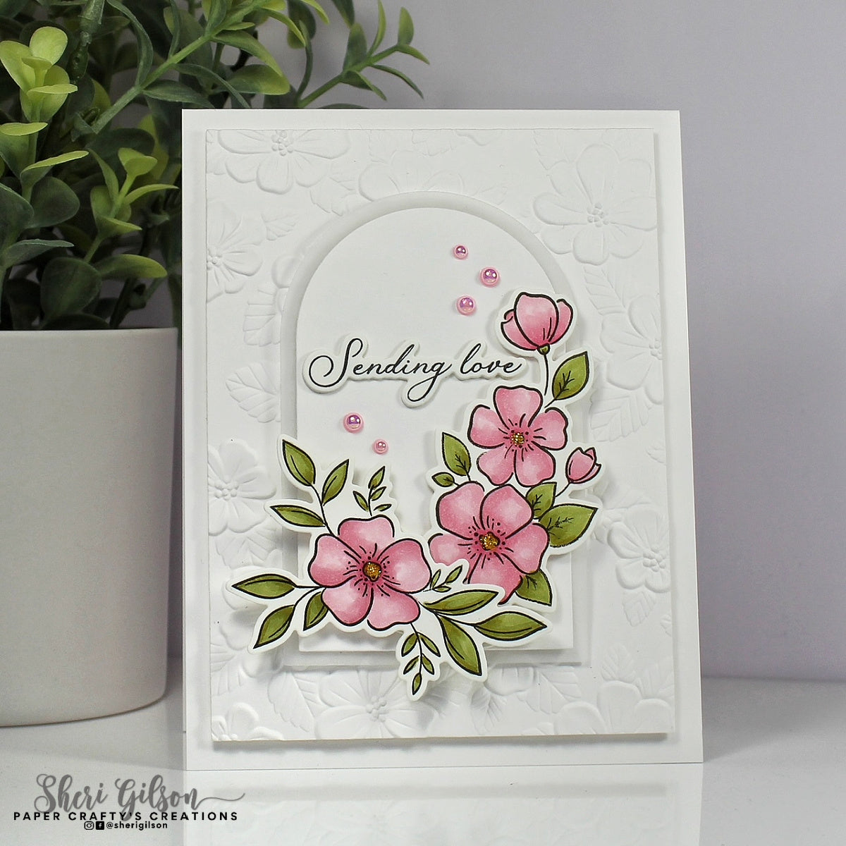 Card with pink flowers and 'Sending love' text on a textured white background