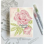 Card with pink peonies and 'Sending You Strength' text, surrounded by stamping tools on a white background.