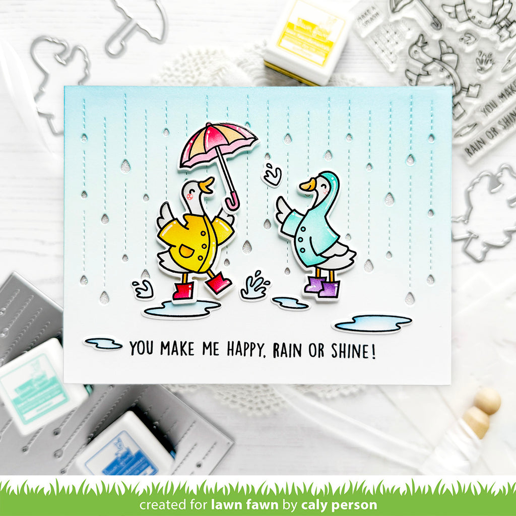 Card with two geese in raincoats and boots holding an umbrella, with sentiment you make me happy, rain or shine