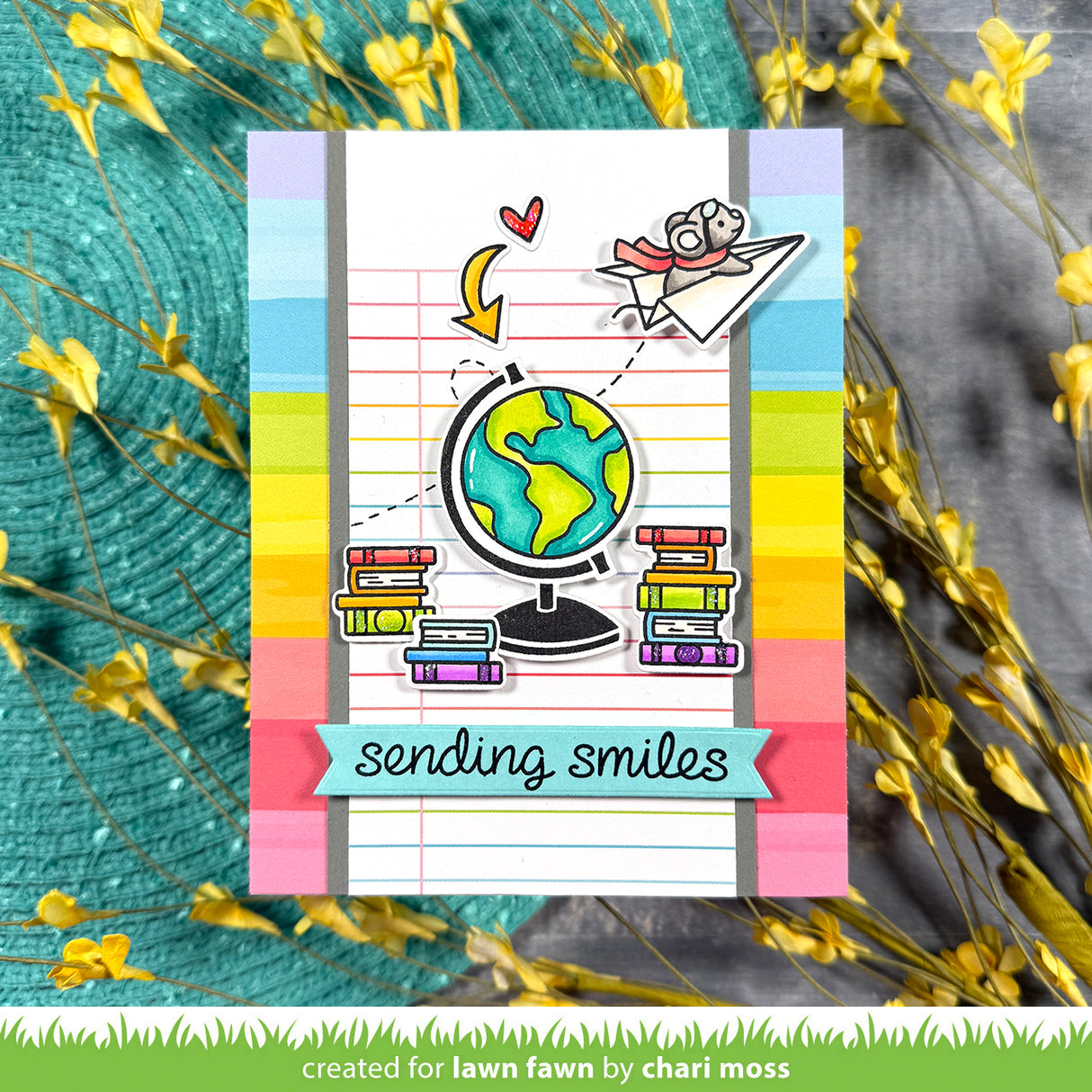 Colorful card with a globe, books, and 'sending smiles' text on a striped background
