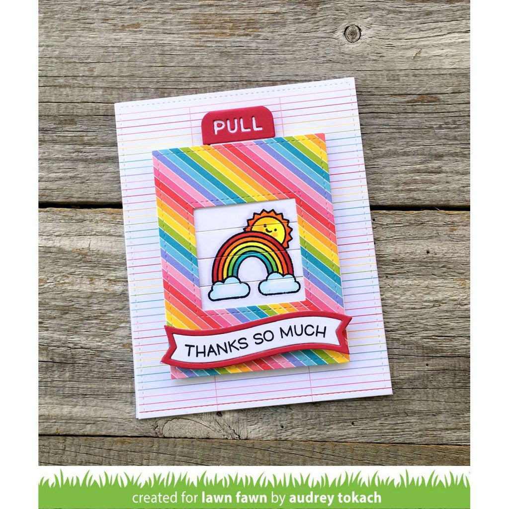 Colorful card with rainbow design and 'Thanks So Much' text on a wooden surface, created by Audrey Tokach for Lawn Fawn.