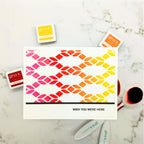 Colorful geometric patterned card with 'gina k.' stamps on a marble surface