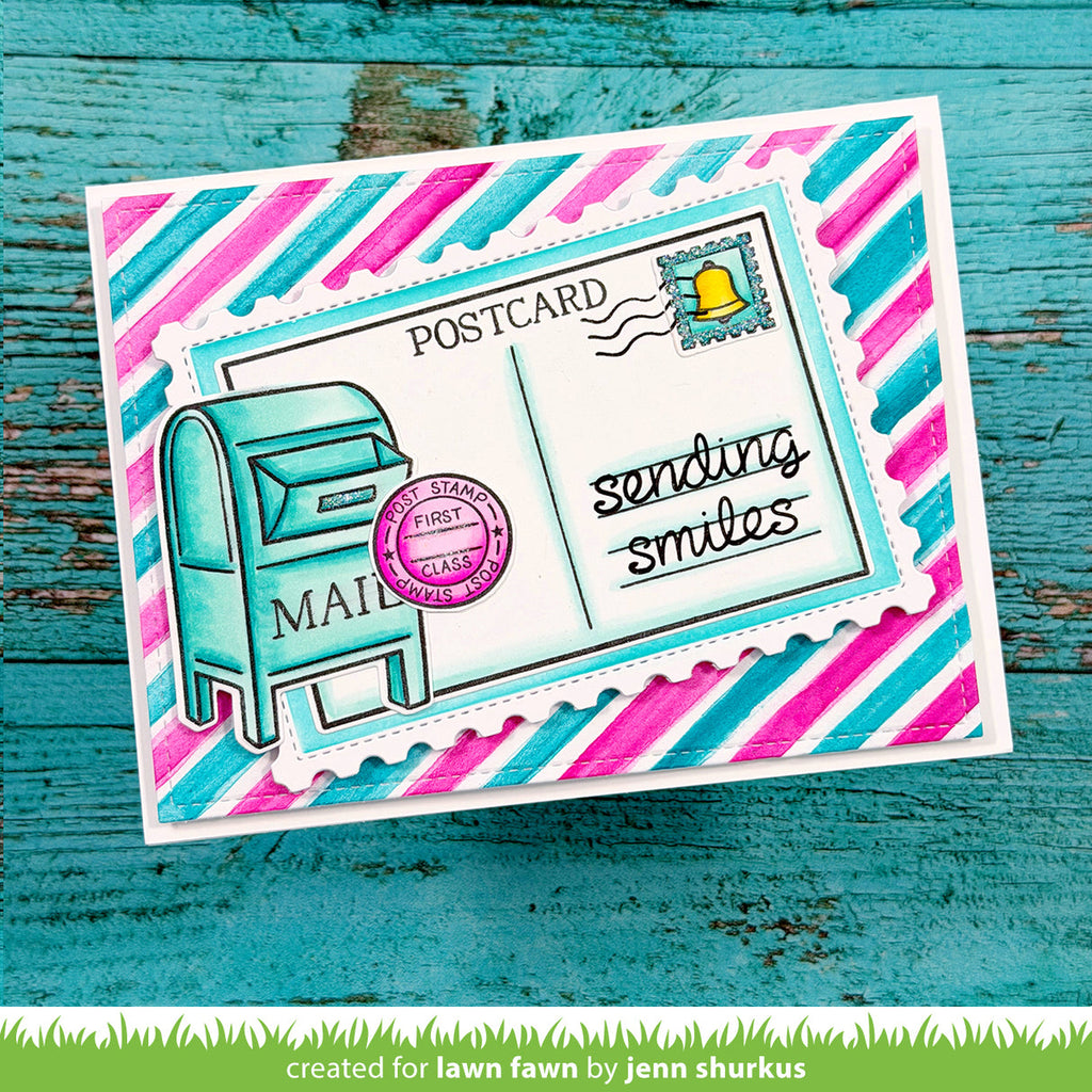 Colorful postcard with striped border and mailbox illustration on a teal wooden background