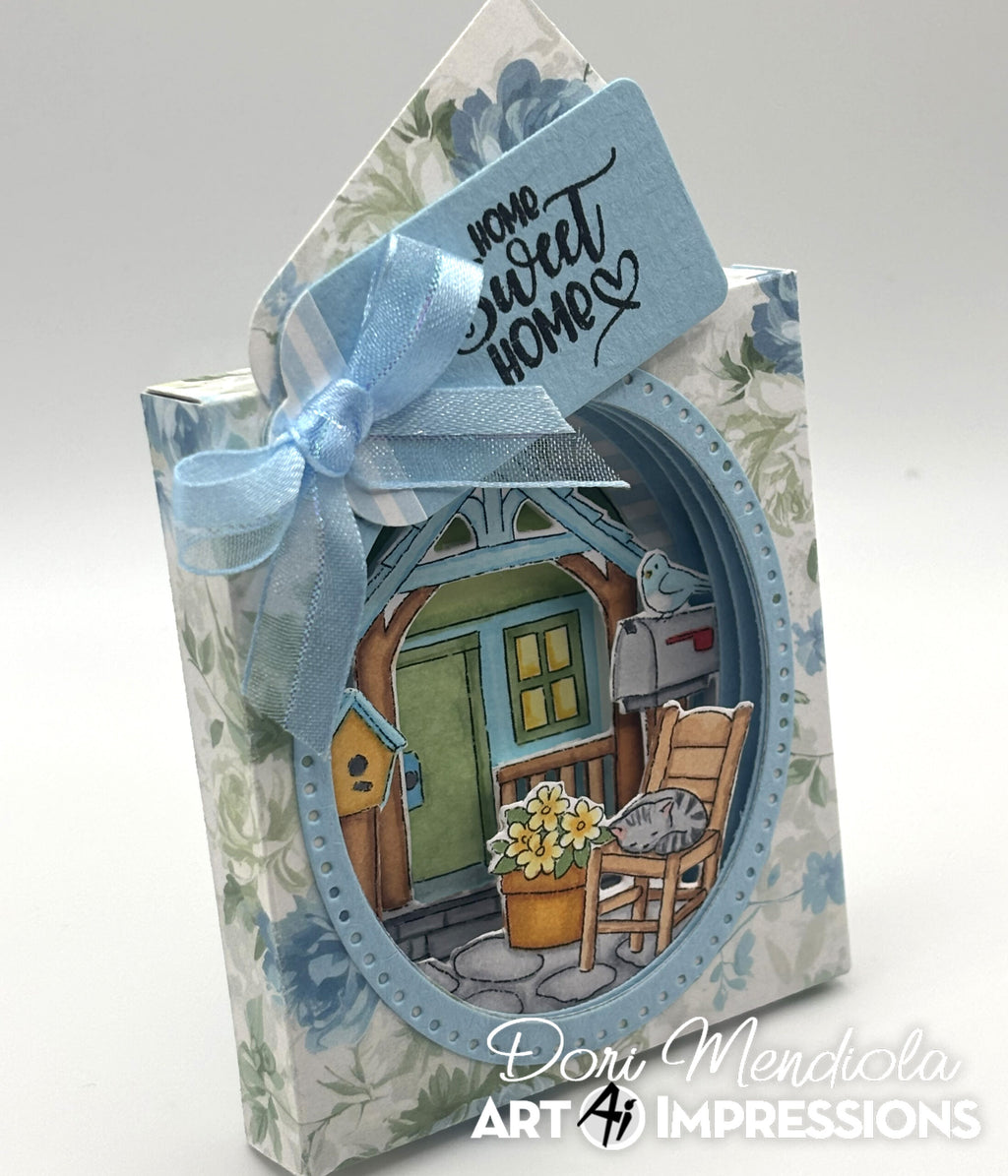 Dimensional project with blue floral background and home sweet home tag and scene with cat on rocking chair and bird on mailbox