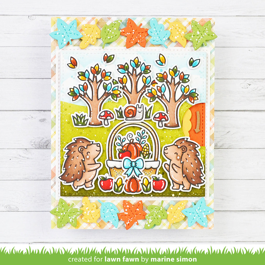 Colorful card with hedgehogs, trees, and autumn elements on a wooden background