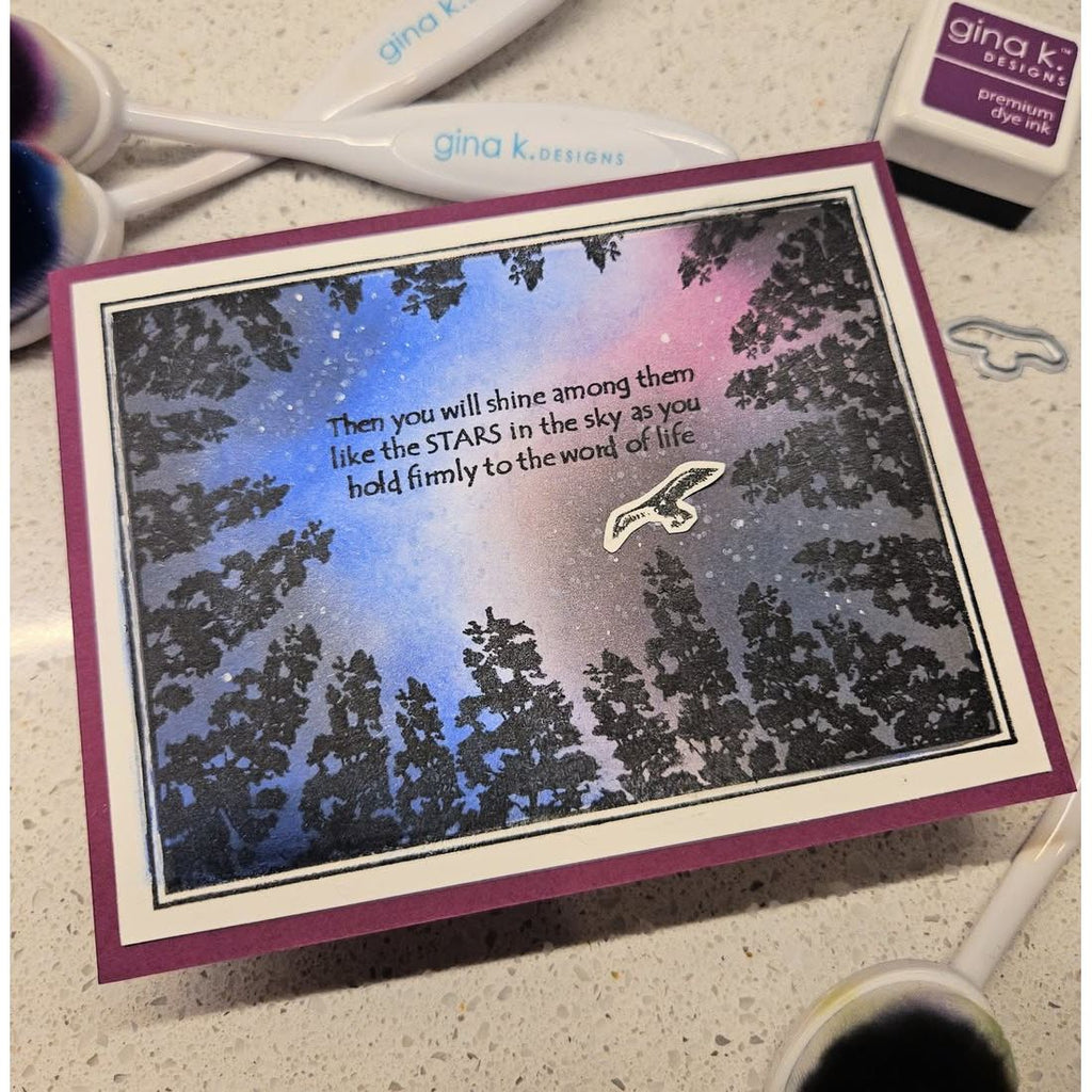 Card with star design and text, surrounded by crafting supplies on a surface.