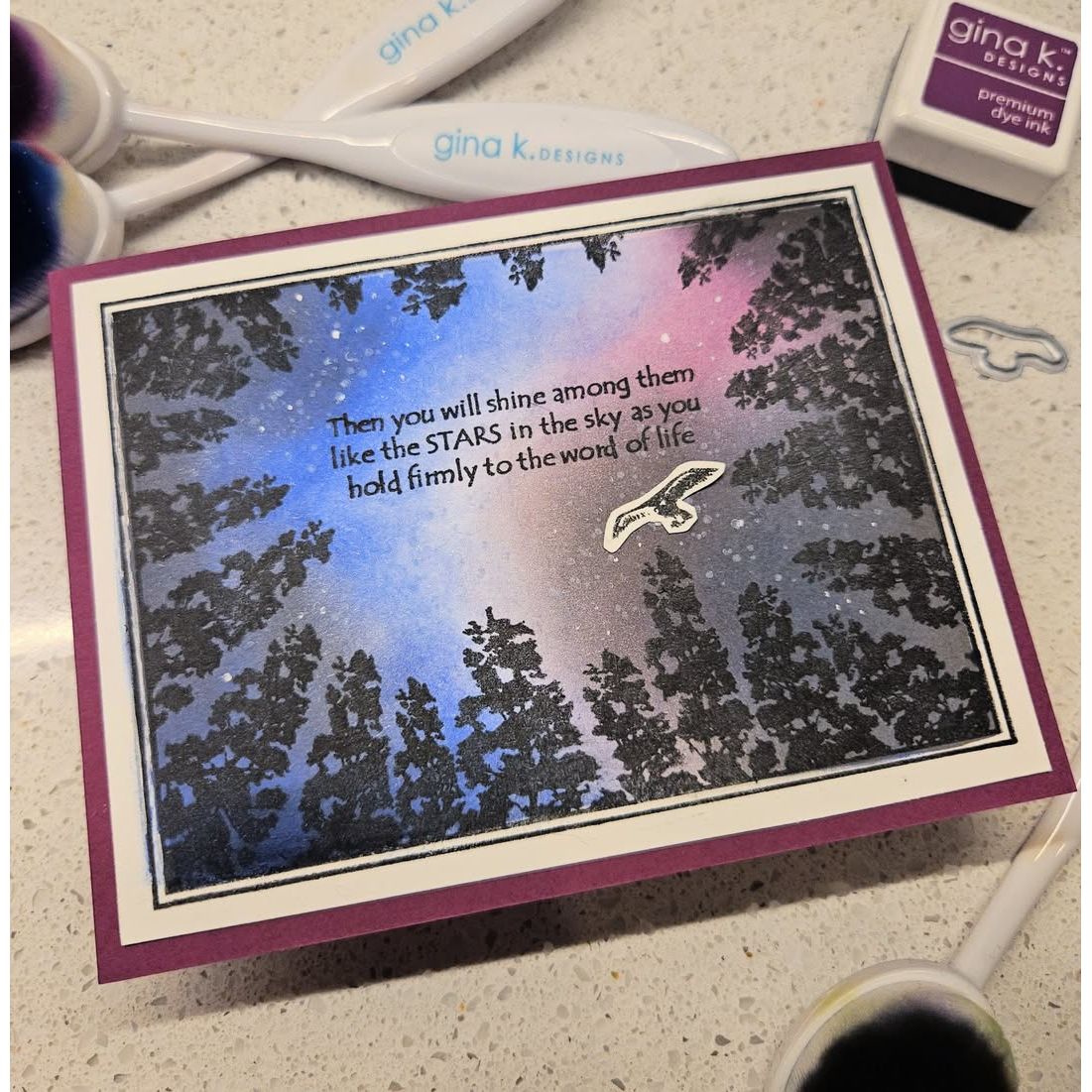 Card with star design and text, surrounded by crafting supplies on a surface.
