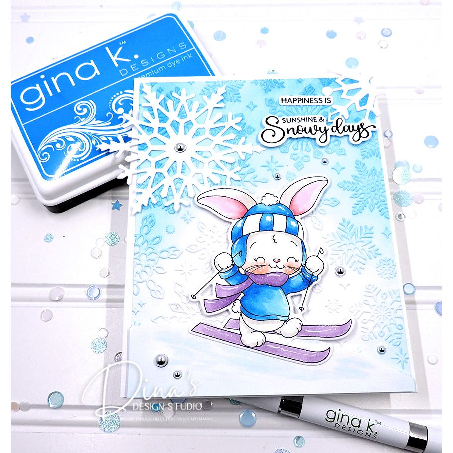 Card with a bunny skiing design, Gina K. Designs stamp and ink pad in the background.