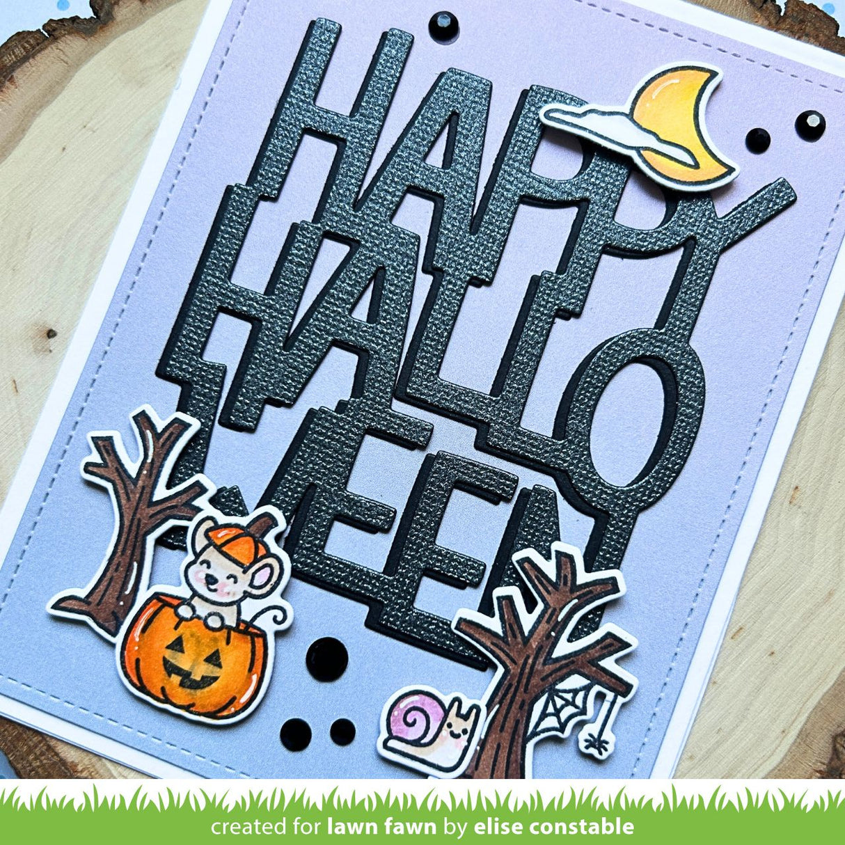 Halloween-themed card with 'Happy Halloween' text and decorative elements on a wooden background.