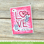 Pink card with 'LOVE IS IN THE AIR' text and cartoon mice on a wooden surface