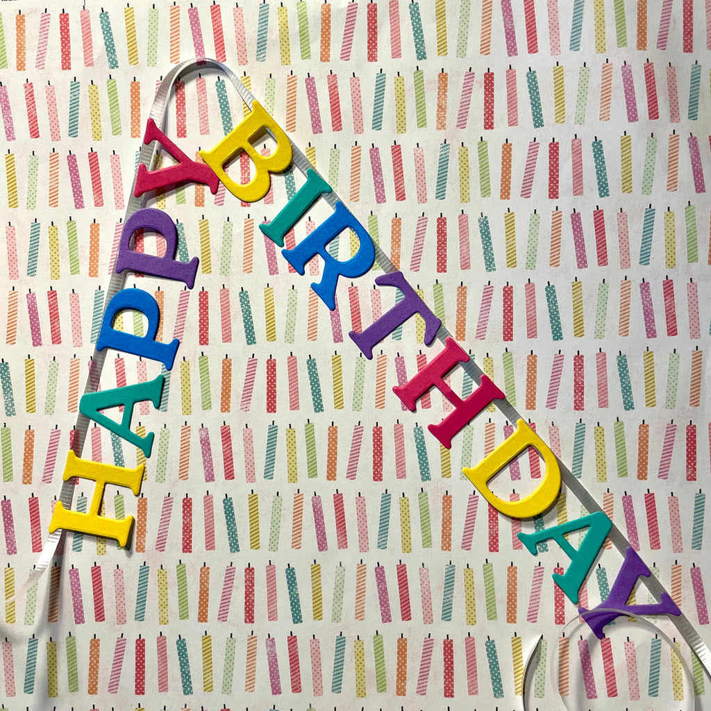 Colorful 'Happy Birthday' banner on a patterned background