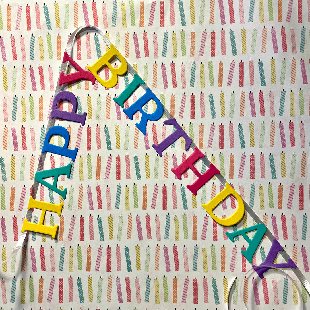 Colorful 'Happy Birthday' banner on a patterned background
