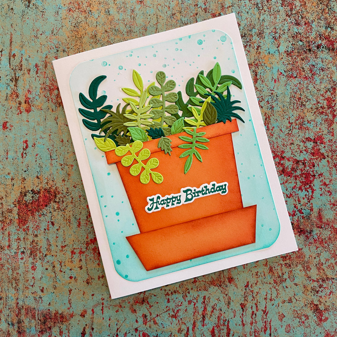 Greeting card with an orange pot of green plants and 'Happy Birthday' text on a textured background.