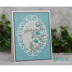 Greeting card with floral design and text 'Sending love' on a light blue background, featuring the brand 'gina k. Designs'.