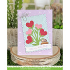 Card with heart design and text 'I like you a mole lot!' on a wooden block with plants in the background.