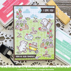 Card with moles and tomato plants, surrounded by stamping supplies on a wooden surface.