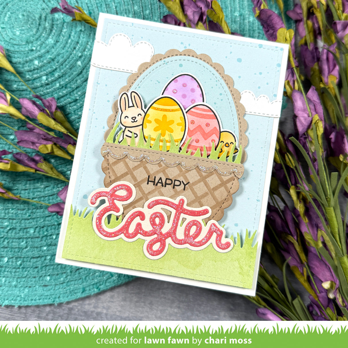 Easter card with a basket of eggs and a rabbit on a textured surface with flowers.
