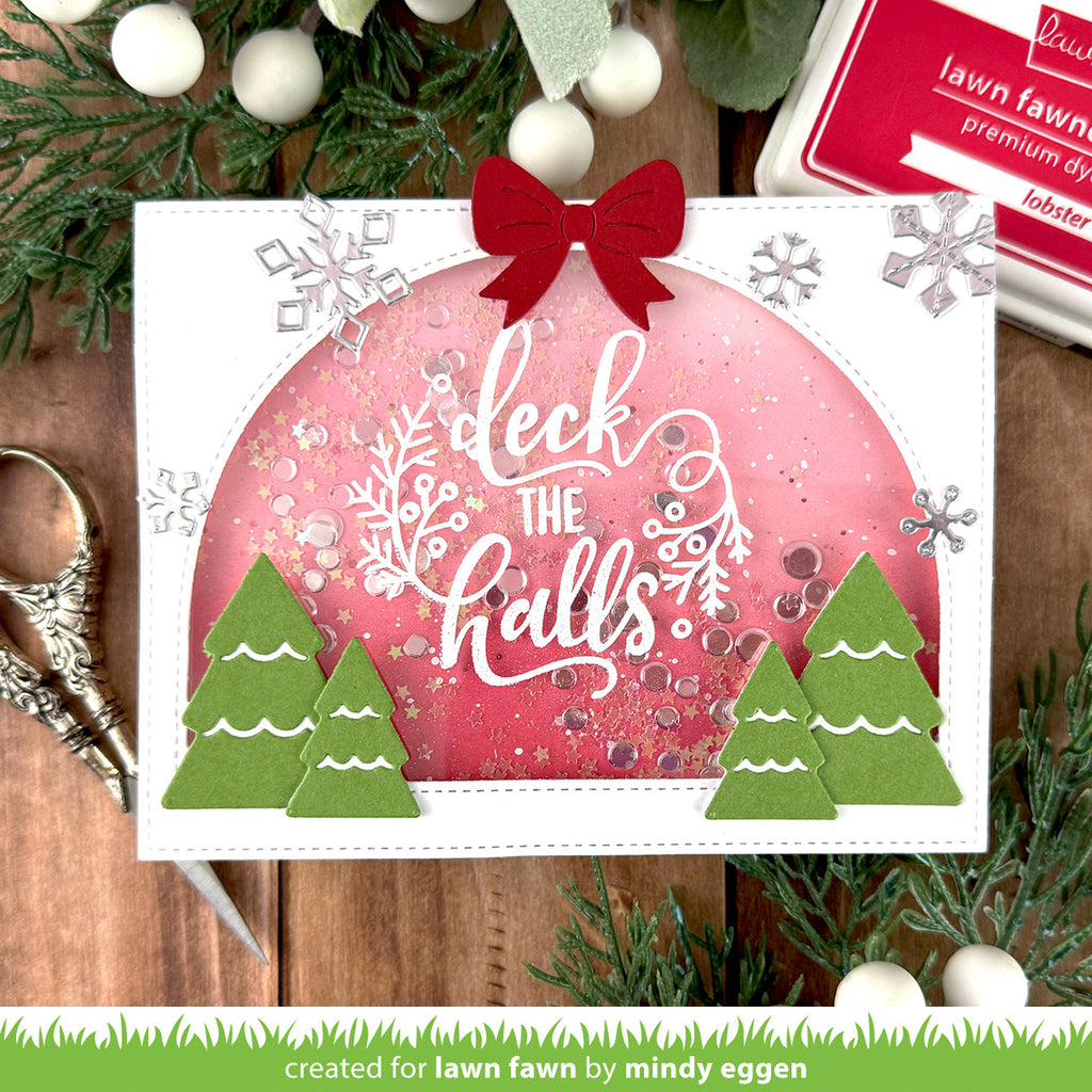 Christmas-themed card with 'deck the halls' text and festive decorations on a wooden surface.
