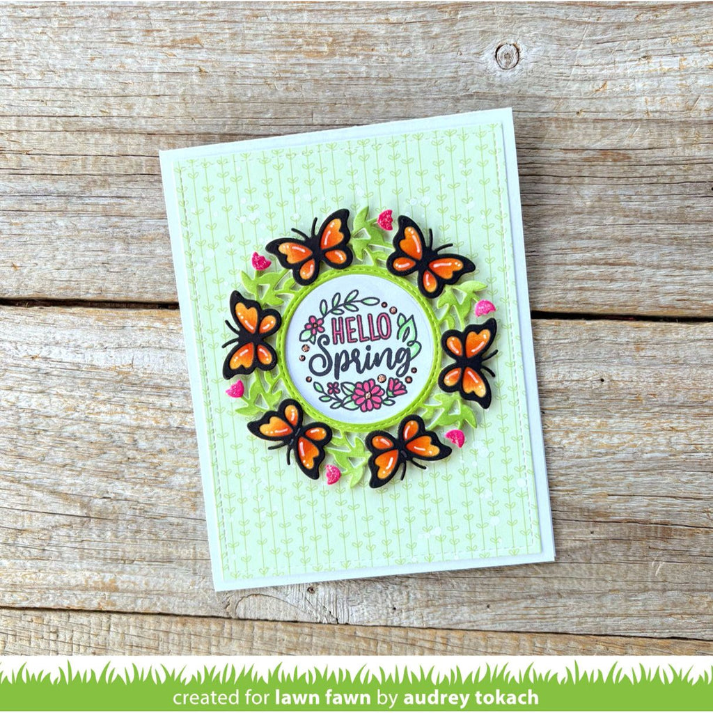 Card with butterflies and 'Hello Spring' text on a wooden surface