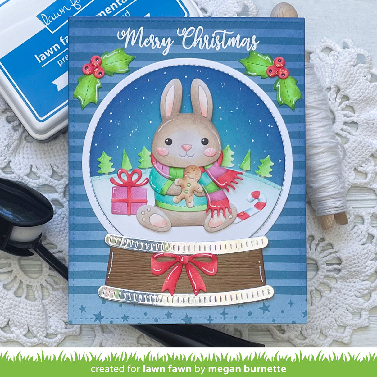 Christmas card with a rabbit in a snow globe on a decorative surface
